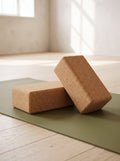 Two natural Cork Yoga Blocks on an olive yoga mat, one flat and one on its side