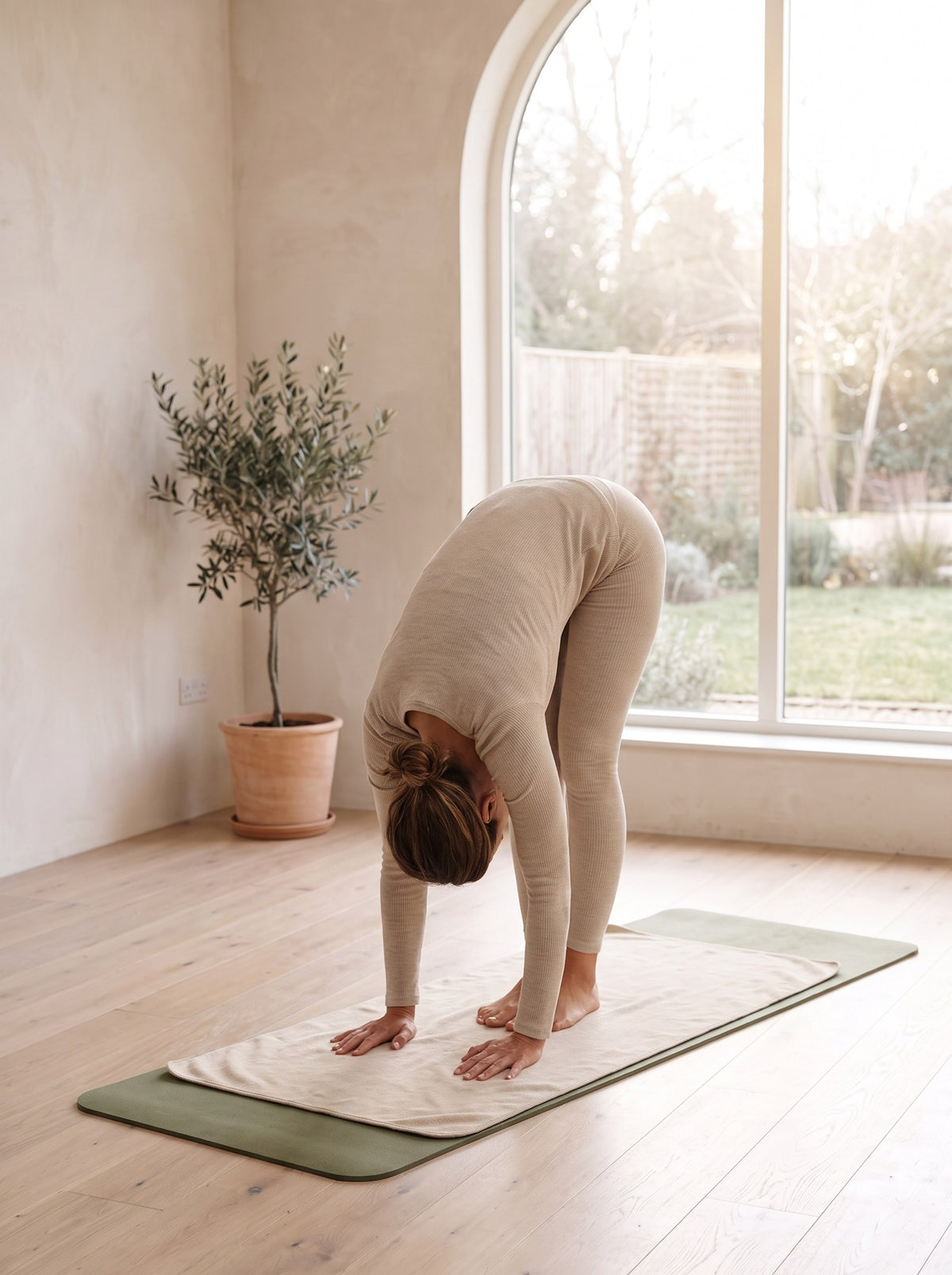 Woman in a forward fold on the Non-Slip Yoga Mat Towel laid over her mat
